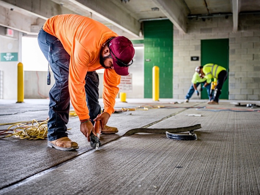 A contractor cutting a joint in a concrete floor